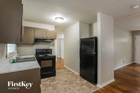 a kitchen with a black refrigerator and a stove and