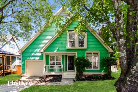 a green house with a green roof and trees