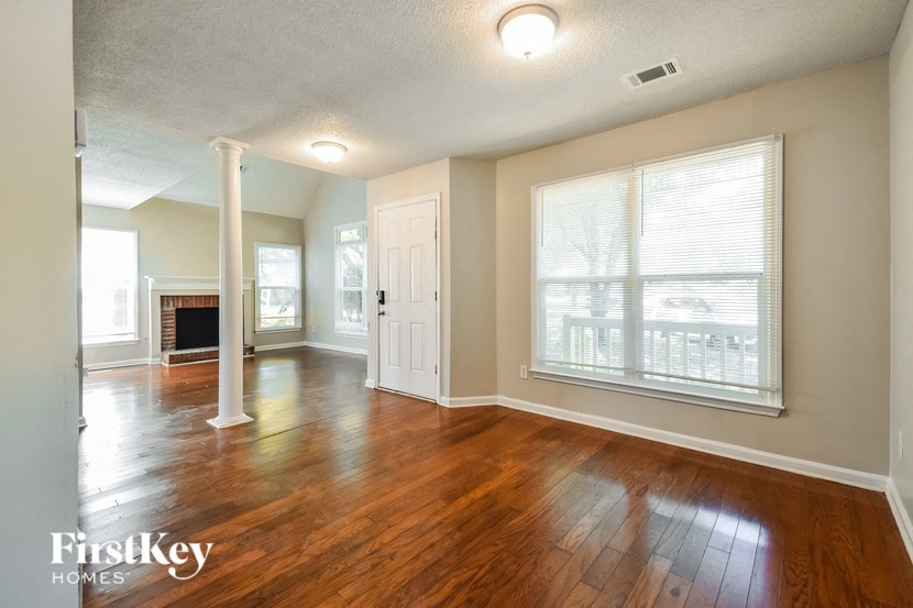 an empty living room with wood floors and a fireplace