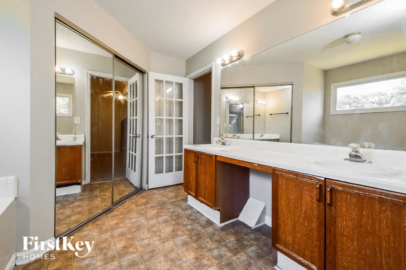 the master bathroom has a large vanity and a large shower
