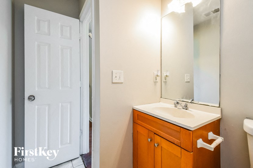 a bathroom with a sink and a mirror and a door