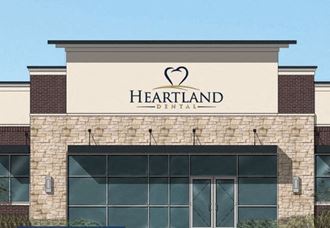the front of a heartland dental clinic with a large sign on the building