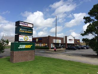 the exterior of a restaurant with a sign for subway and a parking lot