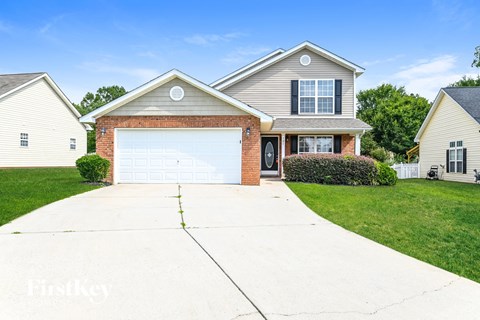 a suburban house with a white garage door on a driveway