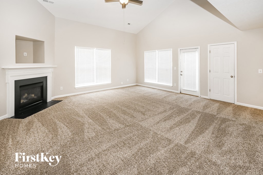 a living room with a fireplace and a carpeted floor