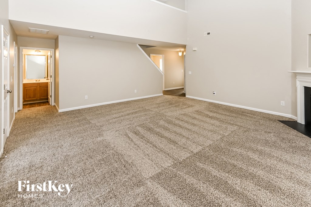 a living room with a carpeted floor and a fireplace