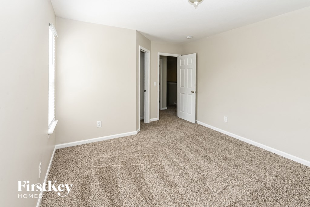 a spacious living room with carpeting and white walls