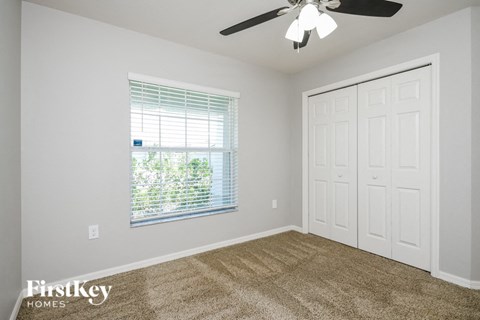 the living room of a home with carpet and a ceiling fan