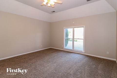 the living room of a home with carpet and a window