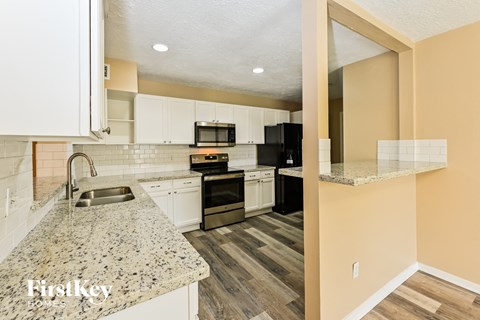 a kitchen with granite counter tops and white cabinets