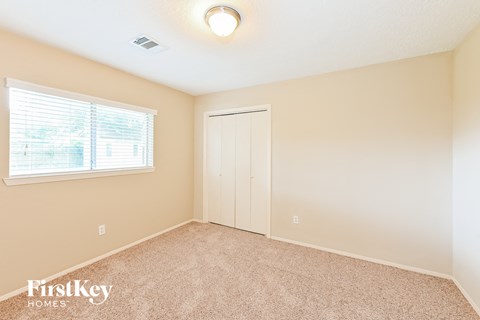 a bedroom with a door to a closet and a window