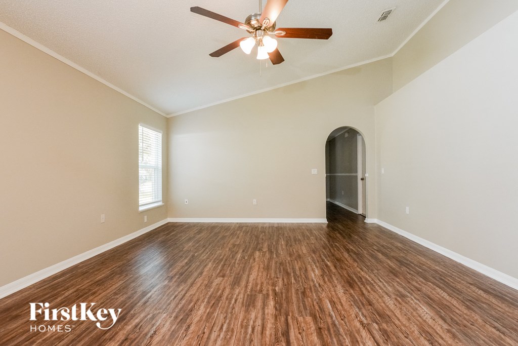the living room of an empty house with a ceiling fan