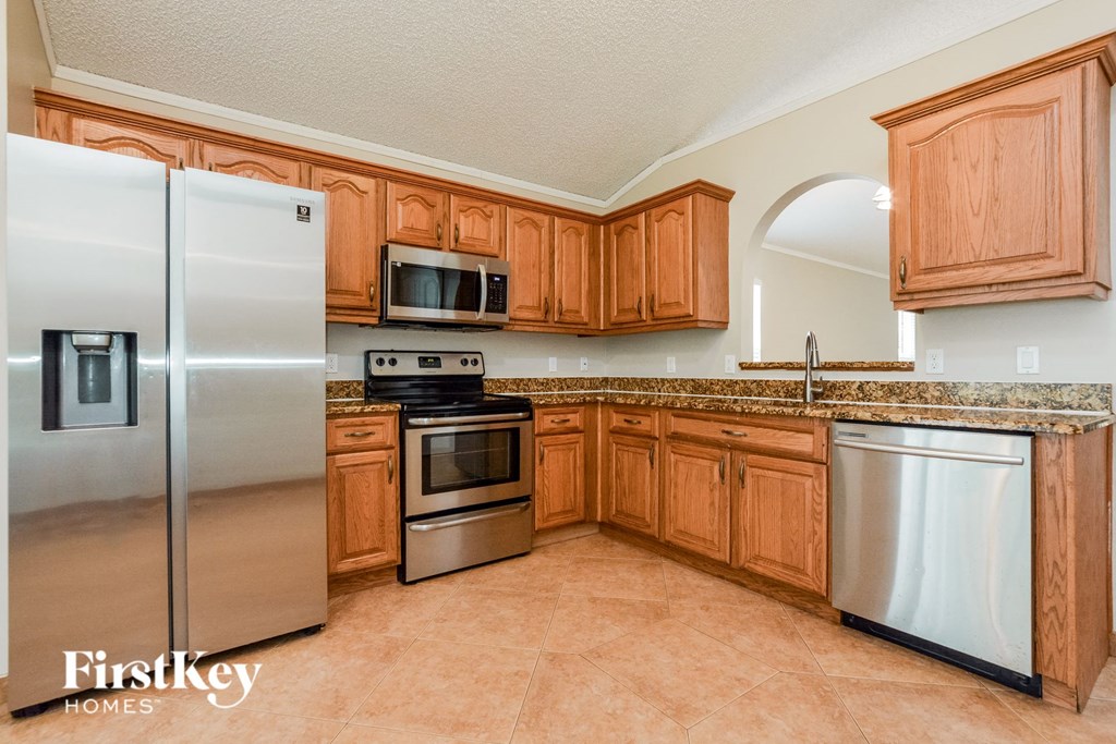 a kitchen with wooden cabinets and stainless steel appliances