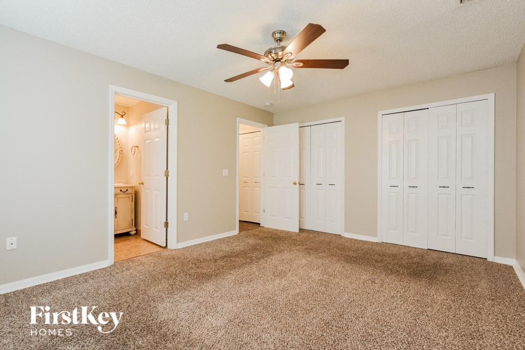 a living room with carpet and a ceiling fan