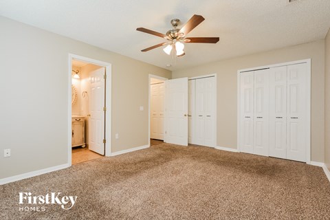 a living room with carpet and a ceiling fan