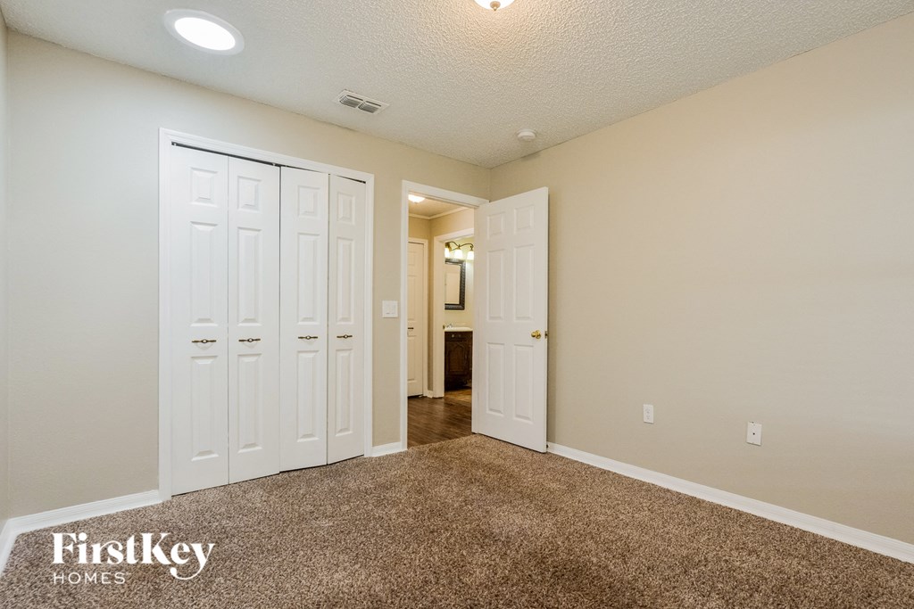 a bedroom with two closets and a door to a hallway