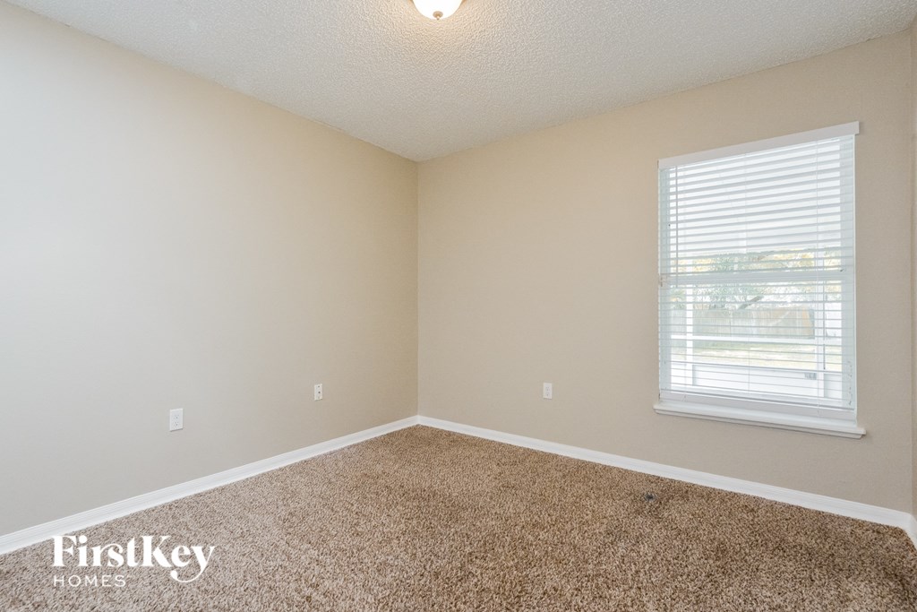an empty room with carpet and a window