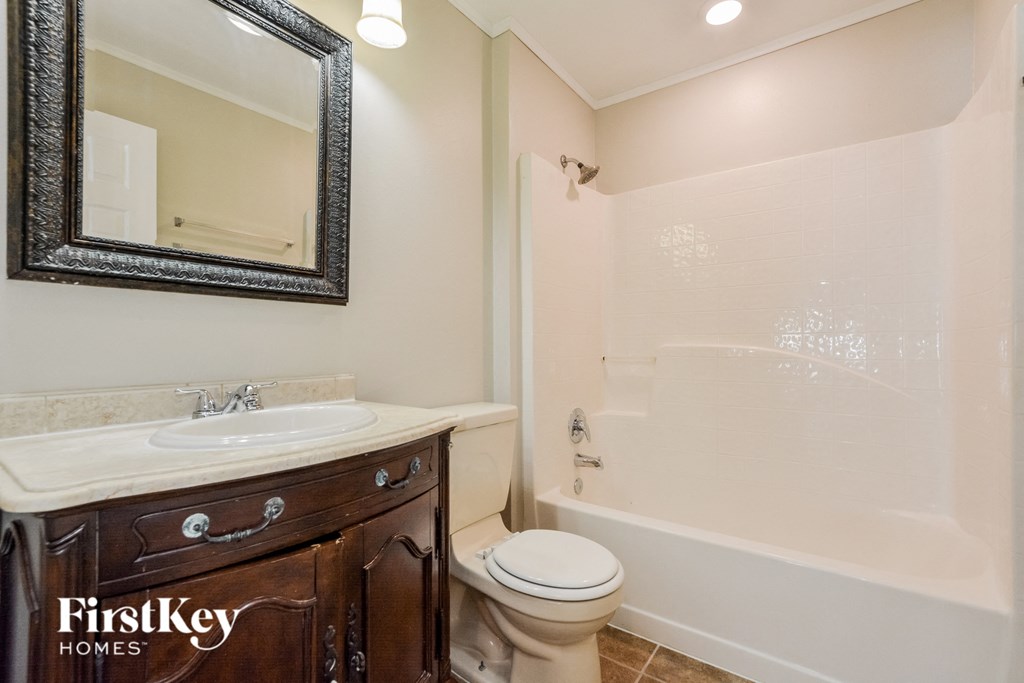 a bathroom with a sink toilet and shower and a mirror
