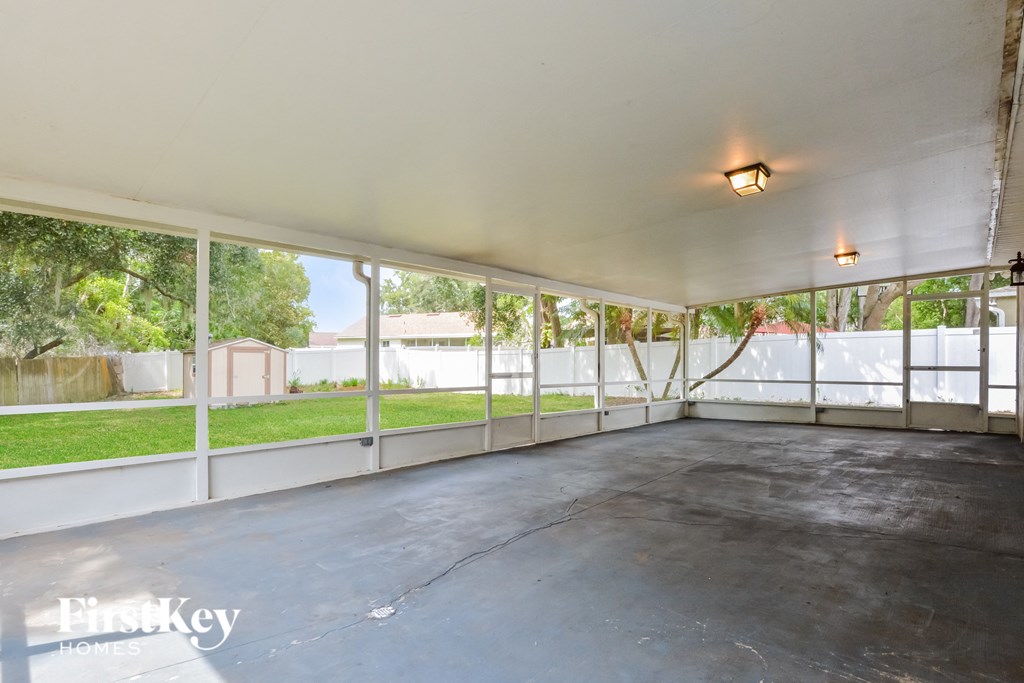 an empty garage with large windows overlooking a yard