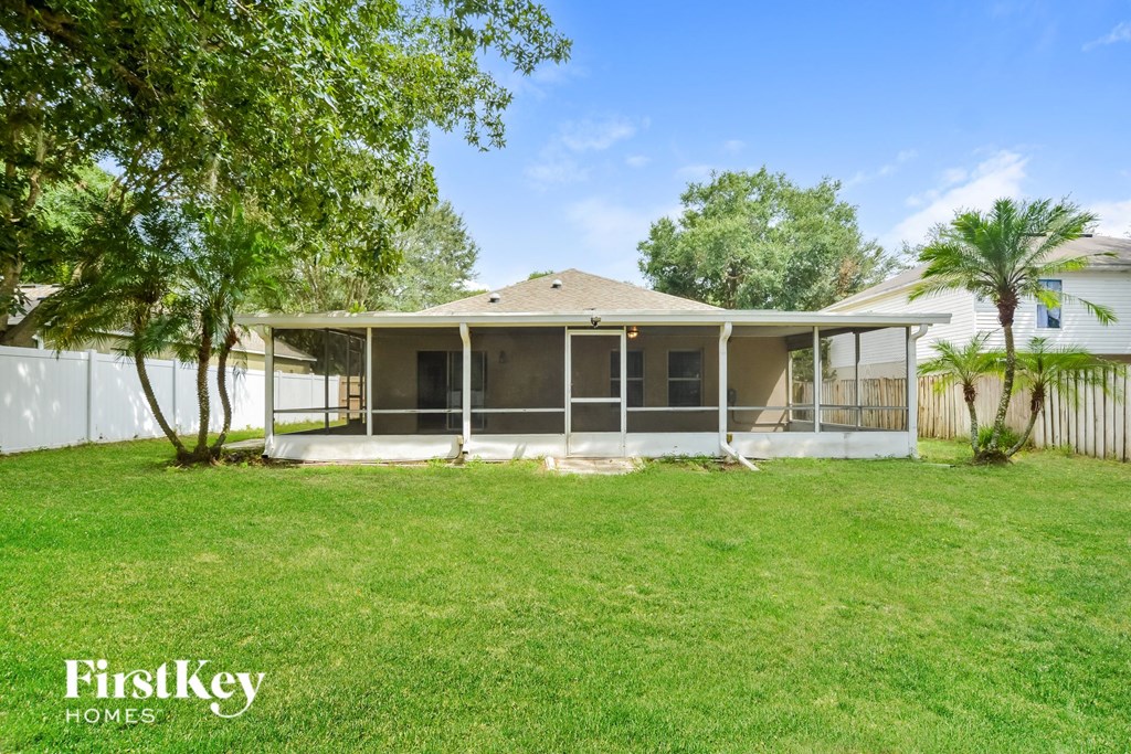 a home with a lawn and a white fence