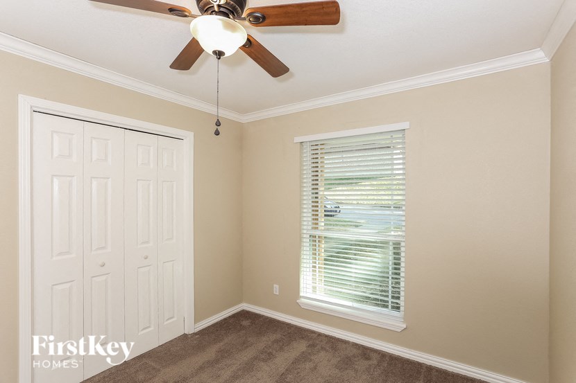 a bedroom with a ceiling fan and a window