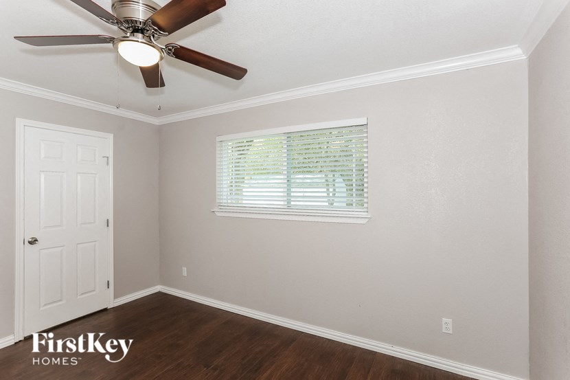 a bedroom with a ceiling fan and a window