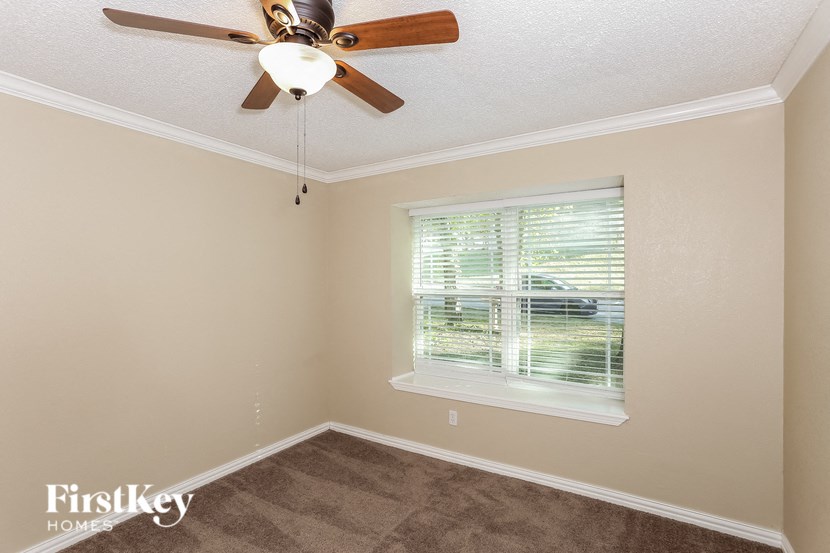 a bedroom with a ceiling fan and a window
