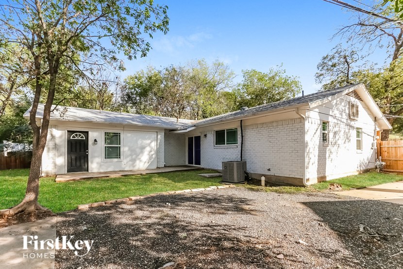 a small white house with a yard and a tree