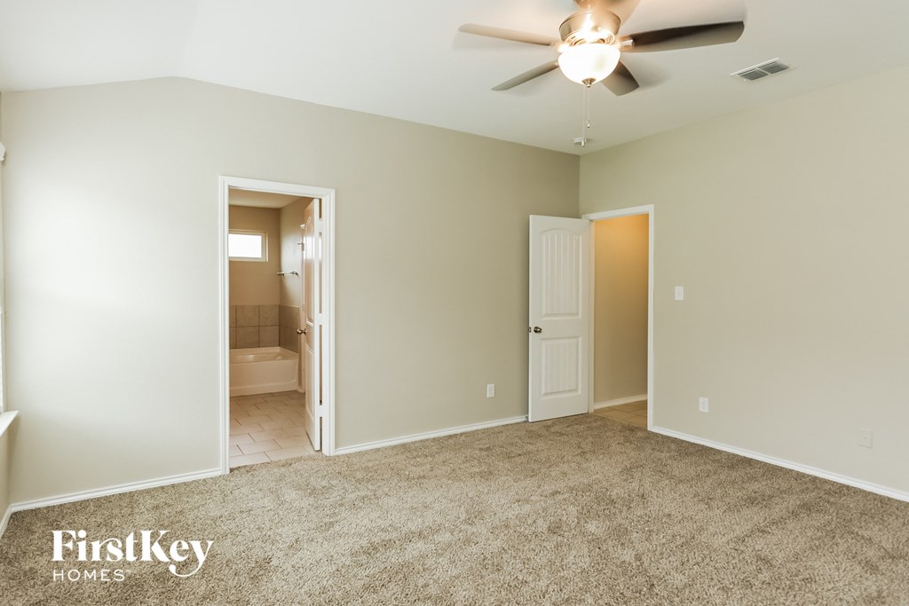 a living room with carpet and a ceiling fan