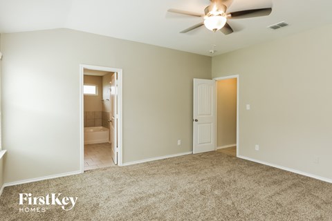 a living room with carpet and a ceiling fan