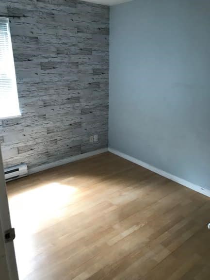 A room with a wooden floor and a stone wall.