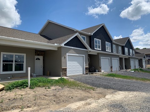 a house with a white garage door and a gravel driveway