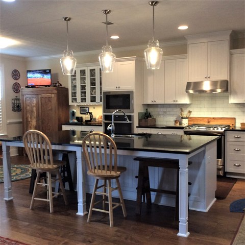 a kitchen with a center island and white cabinets