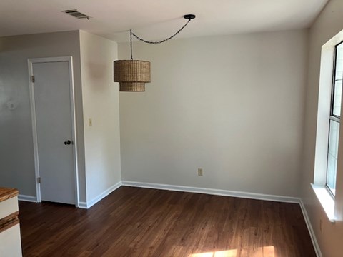 A room with a wooden floor and a white door.