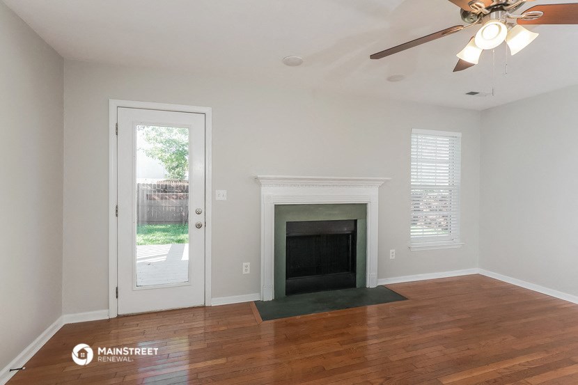 the living room with a fireplace and a door to the backyard