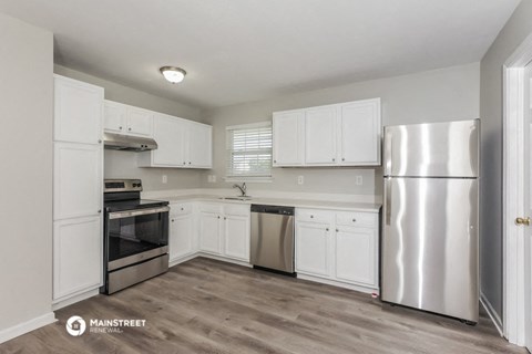 a white kitchen with stainless steel appliances and white cabinets