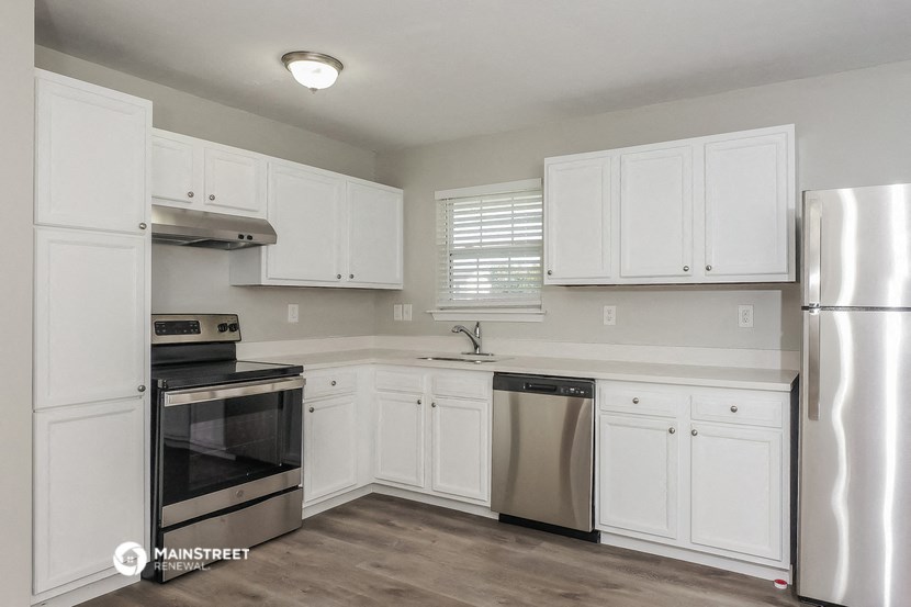a kitchen with white cabinets and stainless steel appliances