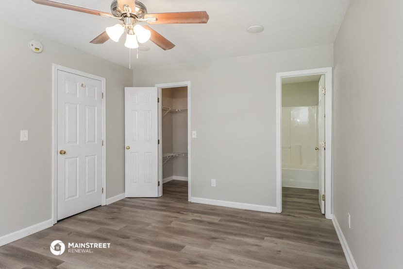 a bedroom with a ceiling fan and a closet