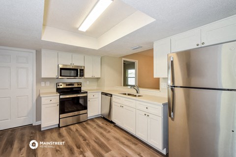 a kitchen with white cabinets and stainless steel appliances
