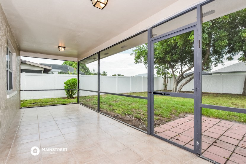 a patio with sliding glass doors overlooking a yard
