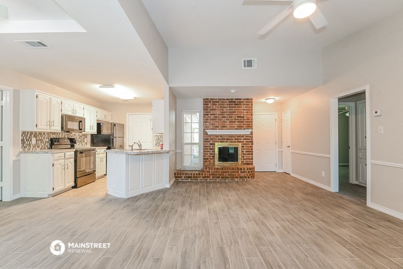 the living room and kitchen of an empty house with a fireplace
