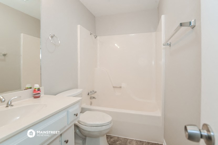 a white bathroom with a shower toilet and sink