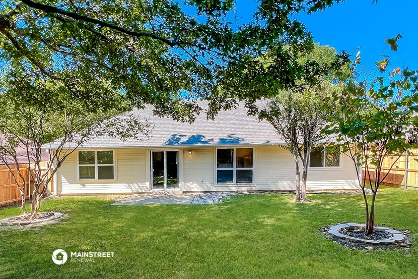 a white house with a lawn and trees