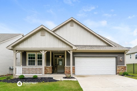 the front of a house with a driveway and a garage door