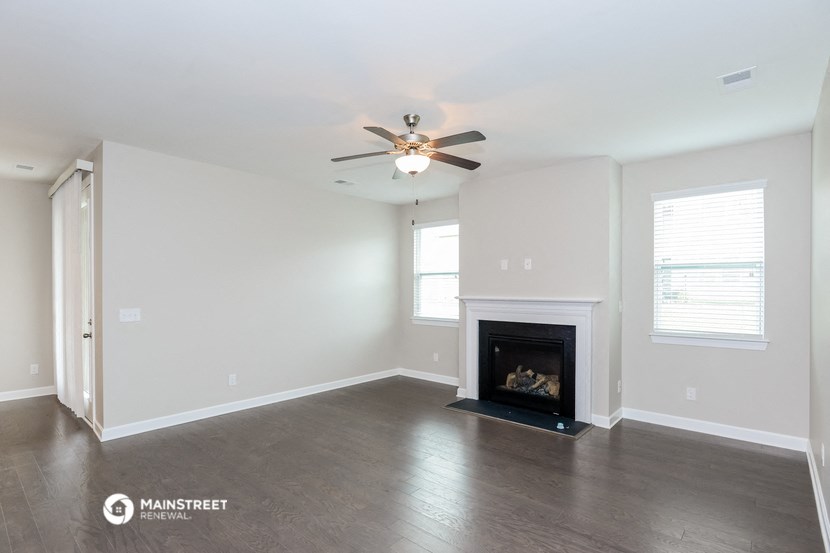 the living room with fireplace and ceiling fan