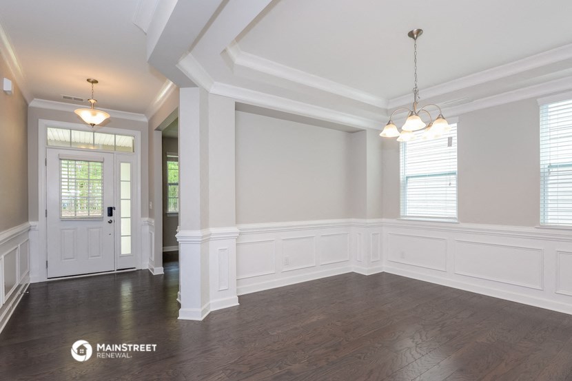 an empty living room with white walls and a white door