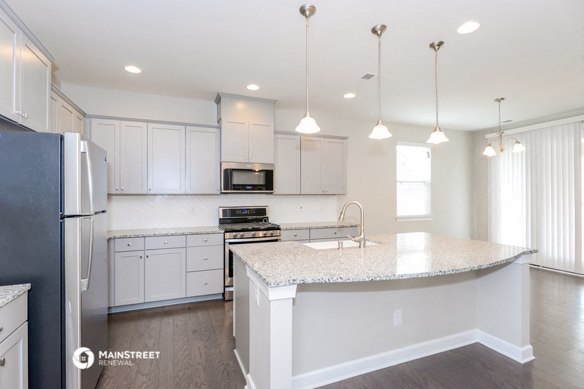a kitchen with white cabinets and a marble counter top