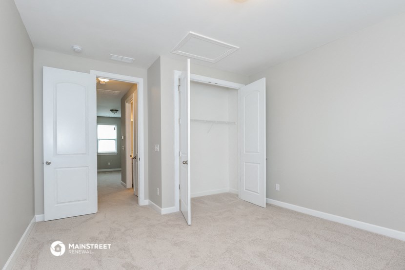 a bedroom with two closets and a hallway with two doors