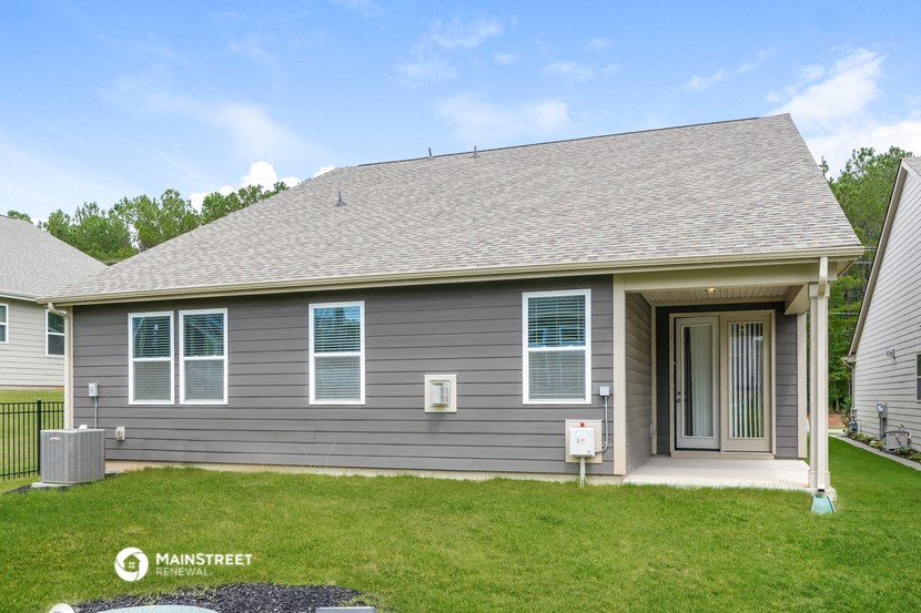 the front of a gray house with a porch and green grass