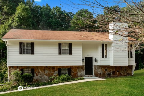 a white house with a stone wall